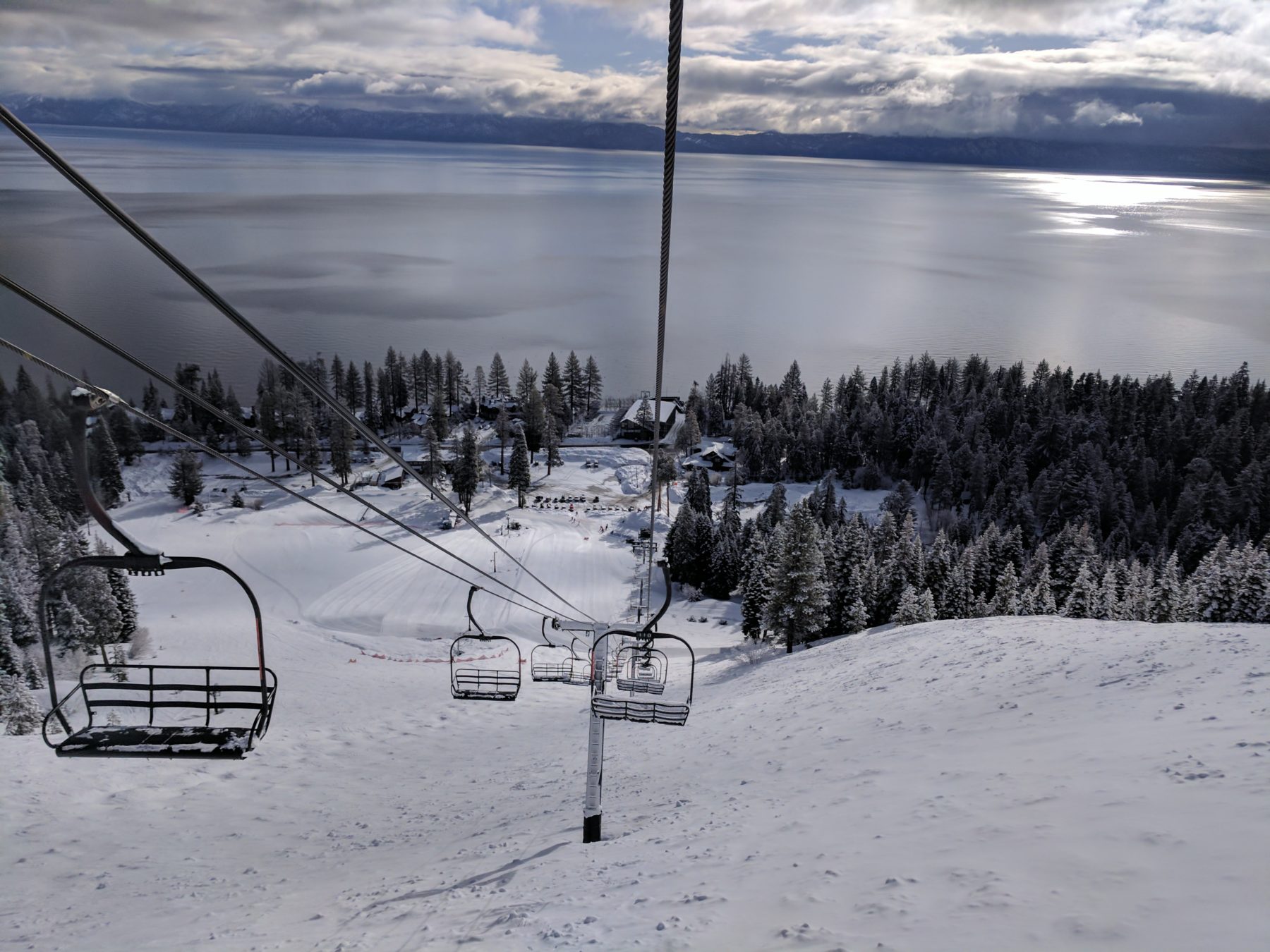Chairlift overlooking a large alpine lake in the winter