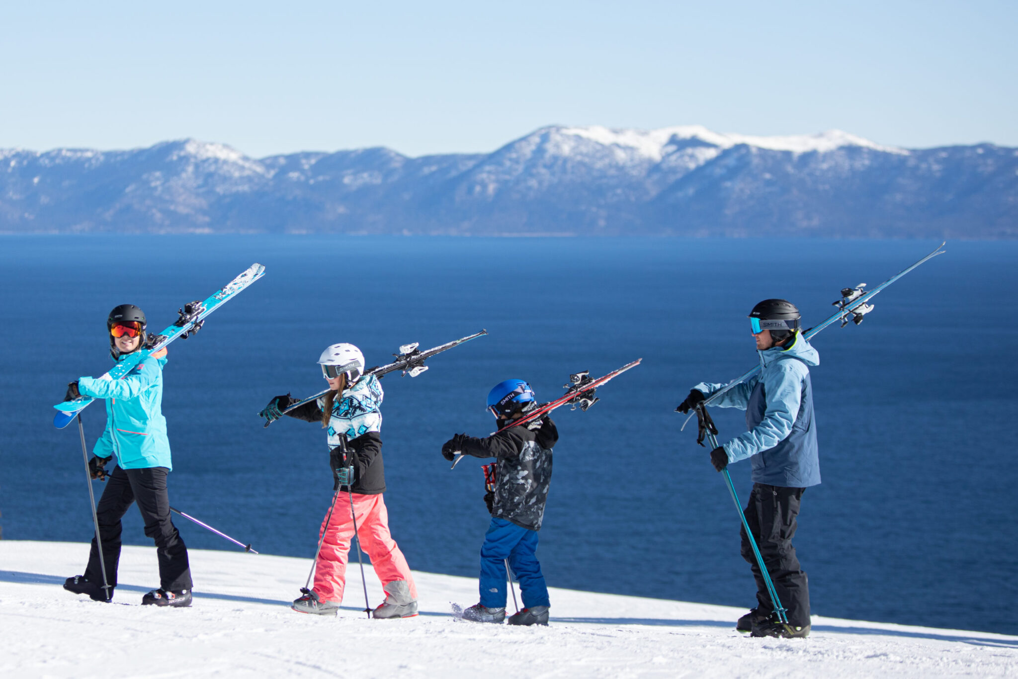 Family skiing together with tahoe view in background